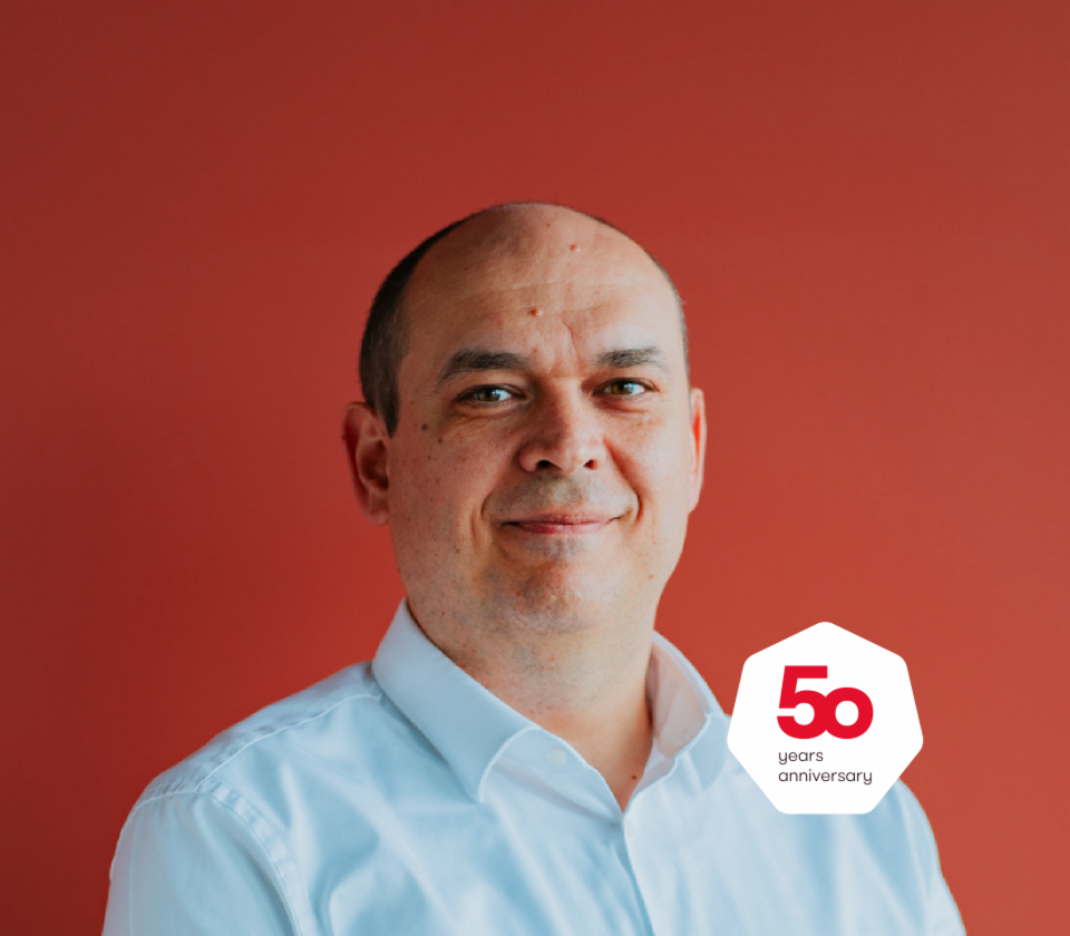 Портрет на Кристијан Мусат, извршен директор на EOS Technology Solutions, пред црвена позадина