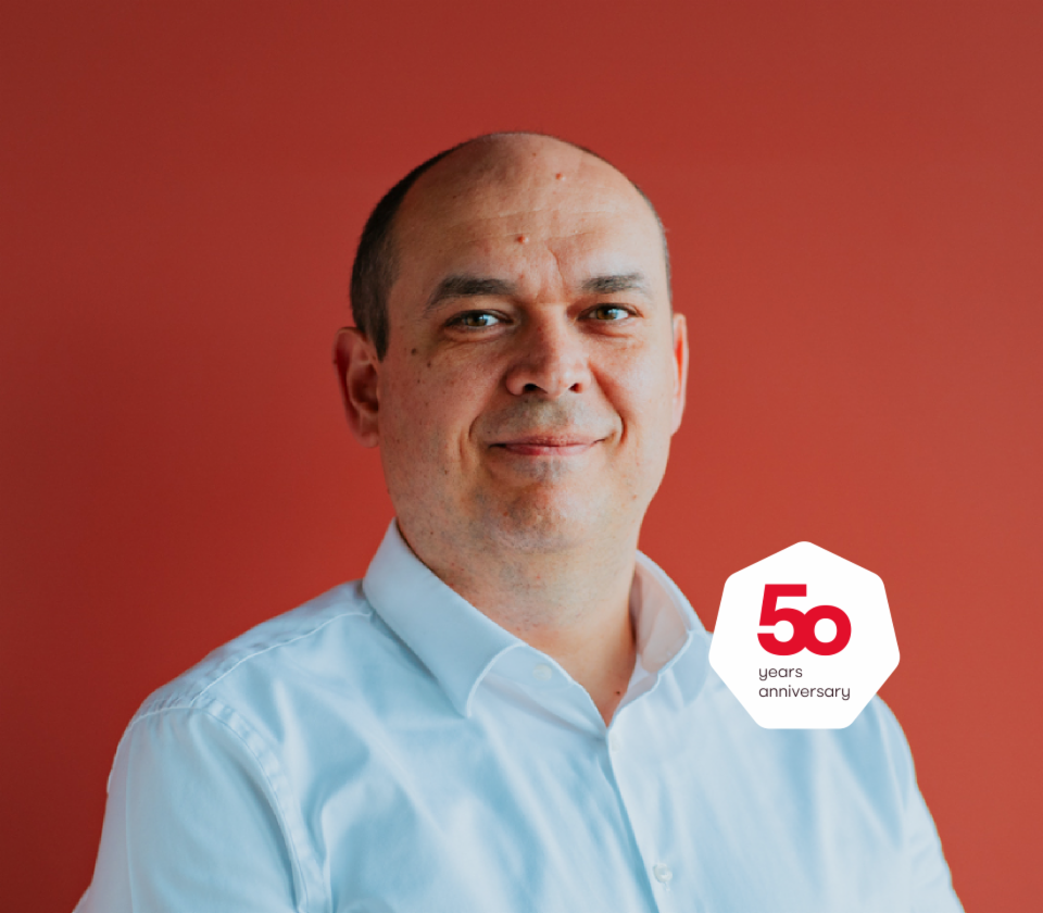 Портрет на Кристијан Мусат, извршен директор на EOS Technology Solutions, пред црвена позадина